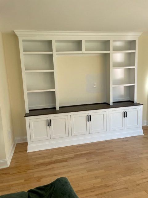 Light wood entertainment center with shelves, cabinets & drawers in living room